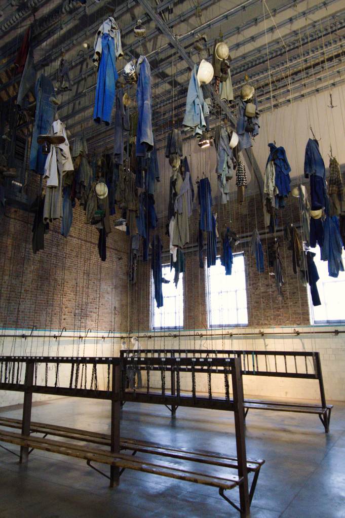 Salle des pendus : des vêtements pendus au plafond au-dessus de rangées de porte manteaux